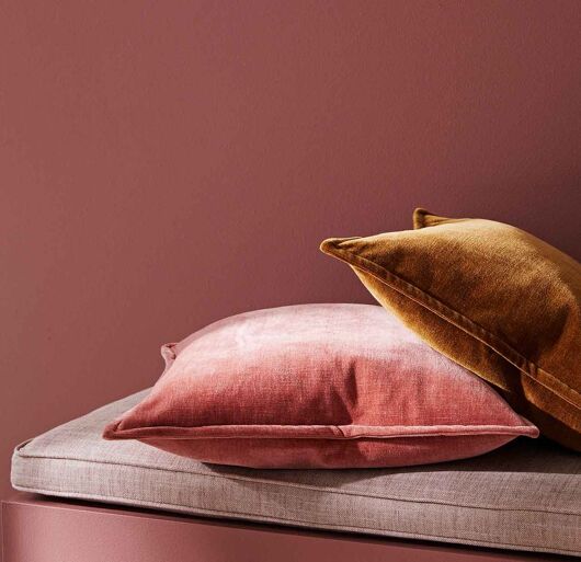 Weave Nova Rhubarb velvet look cushion on day bed